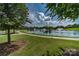 Scenic pond with fountains, surrounded by lush greenery and a paved walking path in a residential community at 10104 Silverling Dr, Waxhaw, NC 28173