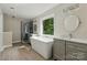 Bright bathroom with a freestanding tub, double vanities, and a separate glass shower at 1014 Sandbox Cir, Indian Trail, NC 28079