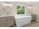 Bright bathroom with a freestanding tub, double vanities, and a large picture window at 1014 Sandbox Cir, Indian Trail, NC 28079