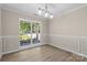 Elegant dining room featuring wainscoting, large windows, and a modern chandelier at 1014 Sandbox Cir, Indian Trail, NC 28079