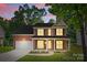 Charming two-story brick home with well-manicured lawn and inviting front porch with chairs at 1014 Sandbox Cir, Indian Trail, NC 28079
