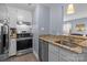 Galley kitchen featuring stainless steel appliances, granite counters, and white cabinets at 1109 E Morehead St # 22, Charlotte, NC 28204