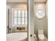 Bright bathroom features a soaking tub, shuttered windows, and a toilet room at 1126 Blowing Rock Cv, Fort Mill, SC 29708