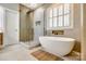 Bright bathroom features a soaking tub, frameless shower, and tile flooring at 1126 Blowing Rock Cv, Fort Mill, SC 29708