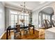 Elegant dining room featuring a modern chandelier, large windows, and a black dining table at 1126 Blowing Rock Cv, Fort Mill, SC 29708