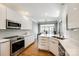 Stylish kitchen with sleek white cabinetry, stainless steel appliances, and a view into the dining area at 1126 Blowing Rock Cv, Fort Mill, SC 29708