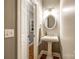 Charming powder room with a pedestal sink, round mirror, and decorative lighting at 1126 Blowing Rock Cv, Fort Mill, SC 29708