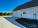 Side view of the home showcasing a bright white exterior, garage, and meticulous landscaping at 1160 Springlake Rd, York, SC 29745
