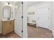 Hallway view of a bathroom vanity with a modern faucet, arched mirror, and a door with black hardware at 1160 Springlake Rd, York, SC 29745
