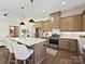 Bright kitchen with an oversized island featuring quartz countertops, pendant lighting, and modern stainless steel appliances at 1160 Springlake Rd, York, SC 29745