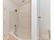 Bathroom features a combined tub and shower with white tile surround at 11705 Silverado Ln, Charlotte, NC 28277