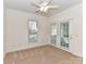 Cozy bedroom featuring carpet flooring, a ceiling fan, and access to outdoor patio through glass doors at 11705 Silverado Ln, Charlotte, NC 28277