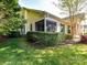 An exterior view showcasing the screened in porch and well manicured lawn at 11705 Silverado Ln, Charlotte, NC 28277