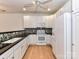 Modern kitchen with white cabinetry, black countertops, mosaic backsplash, and stainless-steel appliances at 11705 Silverado Ln, Charlotte, NC 28277