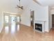Spacious living room featuring hardwood floors, a fireplace, and abundant natural light from the windows at 11705 Silverado Ln, Charlotte, NC 28277