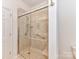 Bathroom with a glass-enclosed shower featuring a built-in seat and grab bar at 11705 Silverado Ln, Charlotte, NC 28277