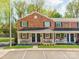 Charming brick townhome featuring a covered front porch and landscaped yard at 1217 Green Oaks Ln # K, Charlotte, NC 28205