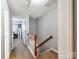 Upstairs hallway featuring carpet and wood railing with access to the bedrooms at 1217 Green Oaks Ln # K, Charlotte, NC 28205