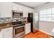 Bright kitchen with granite counters, stainless steel appliances, and a window at 1217 Green Oaks Ln # K, Charlotte, NC 28205