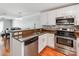 Well-lit kitchen with granite counters, stainless steel appliances, and a breakfast bar overlooking the dining area at 1217 Green Oaks Ln # K, Charlotte, NC 28205