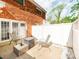 View of the rear brick exterior and back patio with white privacy fence at 1217 Green Oaks Ln # K, Charlotte, NC 28205