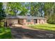 Beautiful brick home with an attached carport and a lush green lawn, surrounded by mature trees at 1218 Donna Dr, Shelby, NC 28152