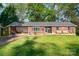 Charming brick home featuring a cozy front porch with benches and a well-maintained lawn at 1218 Donna Dr, Shelby, NC 28152