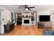 Cozy living room with a white brick fireplace, built-in shelving, and hardwood floors at 1218 Donna Dr, Shelby, NC 28152