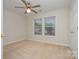 Bright bedroom features neutral carpet, ceiling fan, and natural light from double windows at 12925 Windy Lea Ln, Huntersville, NC 28078