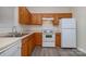 Functional kitchen with wood cabinets, white appliances, and laminate floors at 12925 Windy Lea Ln, Huntersville, NC 28078