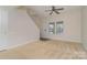 Bright living room with carpet, entry to stairs, and large window at 12925 Windy Lea Ln, Huntersville, NC 28078