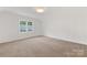Spacious bedroom with neutral carpet, white walls and a window with a view of trees at 1441 Carmel Rd, Charlotte, NC 28226