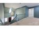 Hallway with blue accent paint, stairwell and hanging pendant light at 1441 Carmel Rd, Charlotte, NC 28226