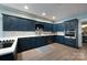A blue kitchen featuring custom cabinets, stainless steel appliances, and wood flooring at 1441 Carmel Rd, Charlotte, NC 28226