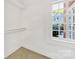 Well-lit walk-in closet with a window for natural light and a single hanging rod at 1441 Carmel Rd, Charlotte, NC 28226
