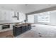 Bright open-concept kitchen with white cabinets, a dark island, and stainless steel appliances at 1504 Baileys Run, Gastonia, NC 28056
