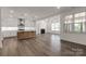 Open-concept living space with a modern fireplace, gourmet kitchen, hardwood floors, and lots of natural light at 1504 Baileys Run, Gastonia, NC 28056