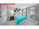 Stylish bedroom with a vibrant turquoise bedspread, modern accents, and a large mirror at 156 Asmodean Ln, Troutman, NC 28166