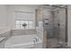 Bright bathroom featuring a luxurious tub, a separate glass-enclosed shower and a large window at 187 Longleaf Dr, Mooresville, NC 28117
