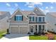 Charming two-story home featuring a welcoming front porch, a two-car garage, and nicely landscaped front yard at 187 Longleaf Dr, Mooresville, NC 28117