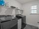 Well-equipped laundry room featuring modern washer and dryer, storage shelves, and a sleek countertop at 187 Longleaf Dr, Mooresville, NC 28117