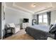 This primary bedroom has neutral walls, carpet, tray ceilings, and lots of natural light at 19010 Hawk Haven Ln, Charlotte, NC 28278
