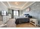 This primary bedroom has a decorative wall, carpet, tray ceilings, and lots of natural light at 19010 Hawk Haven Ln, Charlotte, NC 28278
