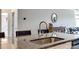 Close-up of the kitchen island featuring granite countertops, a stainless steel sink, and elegant faucet fixtures at 19010 Hawk Haven Ln, Charlotte, NC 28278