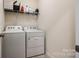A tidy laundry room with a washer, dryer, and overhead shelf for supplies at 19010 Hawk Haven Ln, Charlotte, NC 28278