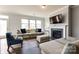Comfortable living room with a fireplace, large windows, and modern decor at 19010 Hawk Haven Ln, Charlotte, NC 28278