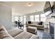 Bright living room featuring a cozy fireplace, large windows, and stylish furnishings at 19010 Hawk Haven Ln, Charlotte, NC 28278