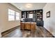 Spacious home office with custom built-in shelving, a large wooden desk, and ample natural light from two windows at 19010 Hawk Haven Ln, Charlotte, NC 28278