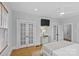 Bright primary bedroom with hardwood floors, ceiling fan, neutral paint, and built-in doors for closet space at 2125 Kenilworth Ave, Charlotte, NC 28203
