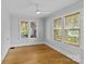 Empty bedroom with hardwood floors, neutral paint, ceiling fan, and large windows providing natural light at 2125 Kenilworth Ave, Charlotte, NC 28203